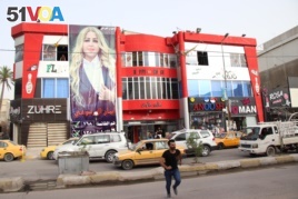New candidates like Iman al-Marsomi, seen in this poster in Baghdad on May 6, 2018, say new leadership will tilt the balance of power toward reform.