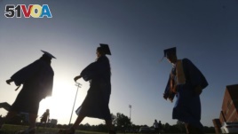In this June 27, 2020, file photo, Saltillo High School seniors make their way to the football field as the sun begins to set for their graduation ceremony in Saltillo, Mississippi. (Thomas Wells/The Northeast Mississippi Daily Journal via AP, File)