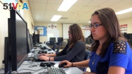 In this April 30, 2015 photo, Leticia Fonseca, 16, left, and her twin sister, Sylvia Fonseca, right, work in the computer lab at Cuyama Valley High School in New Cuyama, Calif. (AP Photo/Christine Armario)