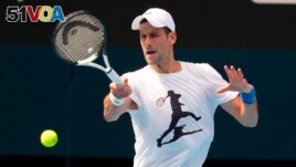 In this photo supplied by Tennis Australia, defending champion Serbia's Novak Djokovic practices in the Rod Laver Arena ahead of the Australian Open at Melbourne Park in Melbourne, Australia, Tuesday, Jan. 11, 2022. 