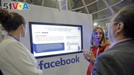 Laura Juanes Micas, of Facebook, center, talks to visitors about the how teaming data and social media can help people live healthier lives, at the Facebook booth, at eMerge Americas technology conference, at the Miami Beach Convention Center, Tuesday, Ju