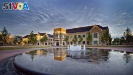 Campus buildings reflect in the water of the fountain at Samson Plaza at the University of Tulsa.
