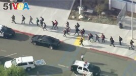 People are lead out of Saugus High School after reports of a shooting on Thursday, Nov. 14, 2019 in Santa Clarita, Calif. (KTTV-TV via AP)