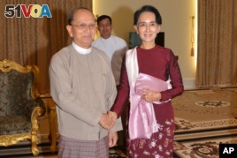 In this image provided by the Myanmar Ministry of Information, Myanmar President Thein Sein, left, shakes hands with opposition leader Aung San Suu Kyi during their meeting at the presidential in Naypyidaw, Myanmar, Dec. 2, 2015.