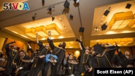 Graduates throw their caps at the conclusion of the Commencement Ceremony for Hult International Business School