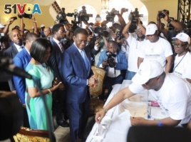 Equatorial Guinea incumbent president and candidate Teodoro Obiang Nguema (C) and his wife Constancia Mangue (L) arrive at the polling station on April 24, 2016 in Malabo during the presidential election vote.