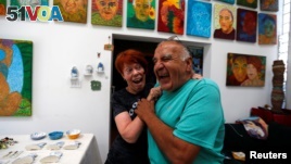 Artists Gonzalo Duran and his wife Cheri Pann laugh in the studio of their Mosaic Tile House in Venice, California, Aug. 26, 2016. 