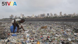 In this June 4, 2018, photo, a man collects plastic and other recyclable material from the shores of the Arabian Sea, littered with plastic bags and other garbage, in Mumbai, India. (AP Photo/Rafiq Maqbool, File)