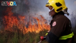 A firefighter monitors a spot fire in an area of the Amazon rainforest, near Porto Velho, Rondonia State, Brazil August 16, 2020. (REUTERS/Ueslei Marcelino)