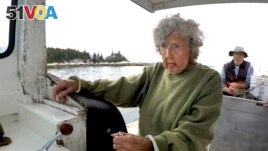 Virginia Oliver, age 101, pilots her son Max Oliver's boat, Tuesday, Aug. 31, 2021, off Rockland, Maine. (AP Photo/Robert F. Bukaty)