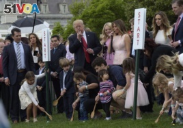 President Donald Trump, center, and first lady Melania Trump, third from right, along with members of the first family, watch as President Trumps blows the whistle to begin an Easter Egg Roll race on the South Lawn of the White House