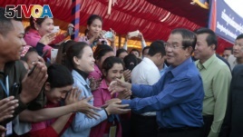 Prime Minister Hun Sen greets garment workers during a visit to a factory outside of Phnom Penh, Cambodia, Wednesday, Aug. 30, 2017. Hun Sen embarked on a country-wide trip to visit the nation's factory workers to hear their hopes and concerns in person.