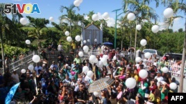 Relatives and supporters of the victims of the infamouse Maguindanao massacre, including Philippine Justice Secretary Leila de Lima (C-partly hidden), release white balloons into the air during the fifth-year anniversary commemoration at the massacre site in Ampatuan, Maguindanao province, on the southern Philippine island of Mindanao, on November 23, 2014.  Senior Philippine officials vowed on November 23 to deliver justice as the nation marked the fifth anniversary of the country's worst political massacre that left 58 dead, including 32 journalists. (AFP/Mark Navales)