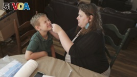 Mendy McNulty swabs the nose of her son, Andrew, 7, Tuesday, July 28, 2020, in their home in Mount Juliet, Tenn. (AP Photo/Mark Humphrey)