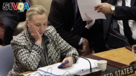 In this March 12, 2012, file photo, then-Secretary of State Hillary Clinton checks her mobile phone after her address to the Security Council at United Nations headquarters.