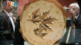 Visitors take a look at the world's biggest and most expensive gold coin, the 