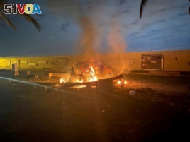 Burning debris is seen on a road near Baghdad International Airport, which according to Iraqi paramilitary groups were caused by three rockets hitting the airport in Iraq, January 3, 2020, in this image obtained via social media. Iraqi Security Media Cell