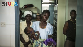 In this file photo, an HIV positive mother holds her sick child at the Thyolo District hospital in Malawi, Nov. 26, 2014.