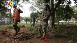 Paraguay Army soldiers clean the backyard of a hospital in an Aedes aegypti mosquito control effort, in Asuncion, Paraguay, Tuesday, Feb. 2, 2016. (AP Photo/Jorge Saenz)