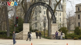 In this Friday, April 29, 2016, photo, people stand near the entrance gate to Northwestern University in Evanston, Ill. (Chris Walker/Chicago Tribune via AP)