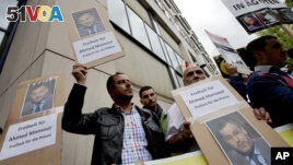 Men protest to support the release of the journalist Ahmed Mansour in Berlin, Germany, Sunday, June 21, 2015. Mansour, 52, a senior journalist with the Qatar-based broadcaster Al-Jazeera, was detained at Tegel airport on Saturday on an Egyptian arrest warrant.