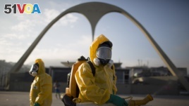 FILE - a health workers stands in the Sambadrome spraying insecticide to combat the Aedes aegypti mosquito that transmits the Zika virus in Rio de Janeiro, Brazil.