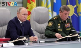 Russian President Vladimir Putin, left, and Chief of General Staff of Russia Valery Gerasimov oversee the test launch of the Avangard hypersonic glide vehicle from the Defense Ministry's control room in Moscow, Russia, Wednesday, Dec. 26, 2018
