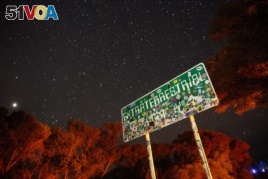 FILE - In this July 22, 2019 file photo, a sign advertises state route 375 as the Extraterrestrial Highway, in Crystal Springs, Nevada, on the way to Nevada Test and Training Range near Area 51.