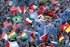 Students in the School of International and Public Affairs wave flags at Columbia University's commencement, Wednesday, May 22, 2019 in New York. More than 14,000 undergraduate and graduate students at the university have completed their studies. (AP Phot
