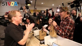 Canopy Growth CEO Bruce Linton applauds after handing Ian Power and Nikki Rose, who were first in line to purchase the first legal recreational marijuana at a Tweed retail store in St John's, Newfoundland and Labrador, Canada October 17, 2018. (REUTERS/Chris Wattie)