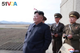 FILE - North Korean leader Kim Jong Un, along with two military officials, observes a Korean People's Air Force training flight, on April 16, 2019. Photo released April 17, 2019 by North Korea's Central News Agency (KCNA).