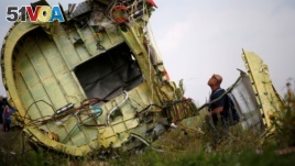 FILE - A Malaysian air crash investigator inspects the crash site of Malaysia Airlines Flight MH17, near the village of Hrabove (Grabovo) in Donetsk region, Ukraine, July 22, 2014. (REUTERS/Maxim Zmeyev/File Photo)