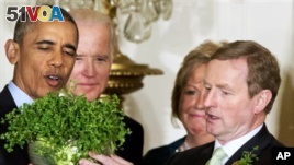 President Barack Obama, left, with Vice President Joe Biden, and Ireland Prime Minister Enda Kenny, right, with his wife Fionnuala Kenny, hold up a bowl of shamrocks at the White House Tuesday. Obama is celebrating his eighth St. Patrick's Day in the White House. (AP Photo/Jacquelyn Martin)
