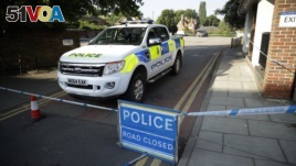 A British police vehicle stands parked next to an area which was extended overnight to include the Lush House car park adjacent to the Queen Elizabeth Gardens park in Salisbury, England, Thursday, July 5, 2018. The area has been linked to what is believed to be another chemical incident involving a nerve agent.