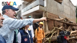 Colombia's President Juan Manuel Santos gestures while visiting a flooded area after heavy rains caused several rivers to overflow, pushing sediment and rocks into buildings and roads in Mocoa, Colombia, April 1, 2017.
