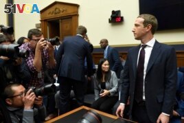 Facebook Chief Executive Officer Mark Zuckerberg is surrounded by photographers during a break in his testimony before the House Financial Services Committee on Capitol Hill in Washington, Wednesday, Oct. 23, 2019. (AP Photo/Susan Walsh)