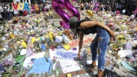 A young woman views of flower tributes for the victims of Monday's explosion at St Ann's square in central Manchester, England, May 25 2017.