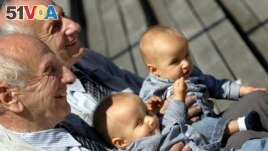 In this Saturday, June 18, 2005 file photo, identical twins Alf, left, and Sven Fehnhanhn, left background, 79, from Kassel, Germany, pose along with seven-month-old Luis Carl, right, and Albert Frank Millgramm, right background at a twins' meeting in Berlin.