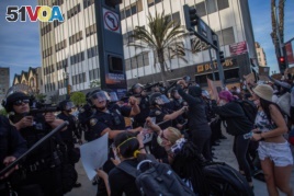 Demonstrators try to block Police officers while they take position aiming towards the crowd