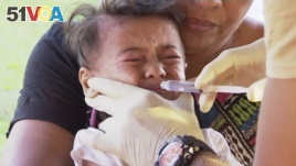 In this November 2019, image from video, a child gets vaccinated against measles at a health clinic in Apia, Samoa.
