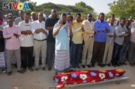 FILE - Mourners pray over the body of Somali journalist Mohamed Ibrahim, a news presenter for Kalsan TV, before his burial in Mogadishu, Somalia, Dec. 12, 2017.