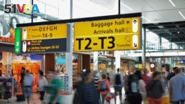 Passengers walk through a busy international airport.