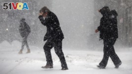 Pedestrians cross the street in downtown Boston, Jan. 4, 2018. A massive winter storm swept from the Carolinas to Maine on Thursday in the United States. (AP Photo/Michael Dwyer)