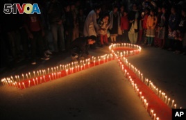 Nepalese women and children from a rehabilitation center for victims of sex trafficking, light candles on the eve of World AIDS Day in Kathmandu, Nepal, Monday, Nov. 30, 2015. (AP Photo/Niranjan Shrestha)