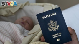 In this photo taken on Jan. 24, 2019, Denis Wolok, the father of 1-month-old Eva's father, shows the child's U.S. passport during an interview with The Associated Press in Hollywood, Fla. (AP Photo/Iuliia Stashevska)