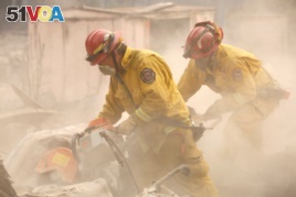 Cal Fire firefighters comb through a house destroyed by the Camp Fire in Paradise, California, U.S., Nov. 13, 2018.