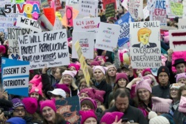 Women with pink hats and signs begin to gather early and are set to make their voices heard on the first full day of Donald Trump's presidency, Saturday, Jan. 21, 2017 in Washington
