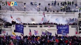 In this Wednesday, Jan. 6, 2021, file photo, violent protesters, loyal to President Donald Trump, storm the Capitol, in Washington. (AP Photo/John Minchillo, File)