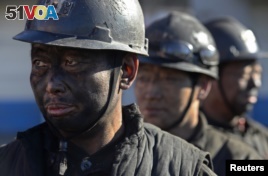 Miners wait in lines to shower during a break near a coal mine in Heshun county, Shanxi province, Dec. 5, 2014.