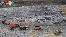 In this photo taken on Friday, April 20, 2018, garbage trucks unload the trash at the Volovichi landfill near Kolomna, Russia. Thousands of people are protesting the noxious fumes coming from overcrowded landfills surrounding Moscow.